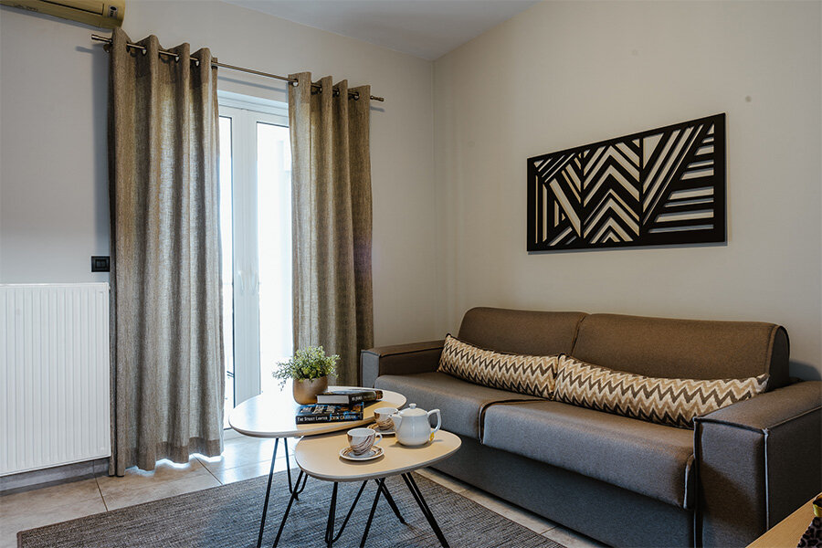 A living room with a couch and tables in a vacation apartment in Nafplio, Greece.